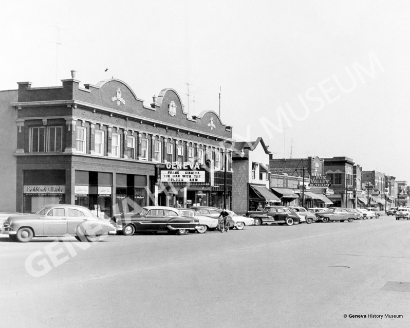 Product Description: Circa 1955 - State Street looking east from Fourth Street, including the north side of the 300 block of West State Street and the Geneva Theatre marquee. After a 75-year run, the Geneva Theatre showed its last film in 2000.</br></br>Available sizes:</br></br>8 x 10 = $20.00; 11 x 14 = $30.00; 16 x 20 = $40.00; 20 x 30 = $55.00; 24 x 36 = $65.00</br></br>In-store pickup free. Shipping available.</br> No. 13 - State Street looking east from Fourth Str